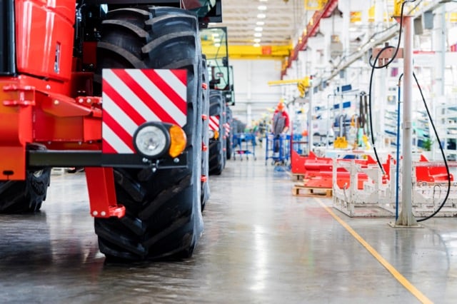 Defocused image of assembly room at big industrial plant manufacturing tractors and harvesters